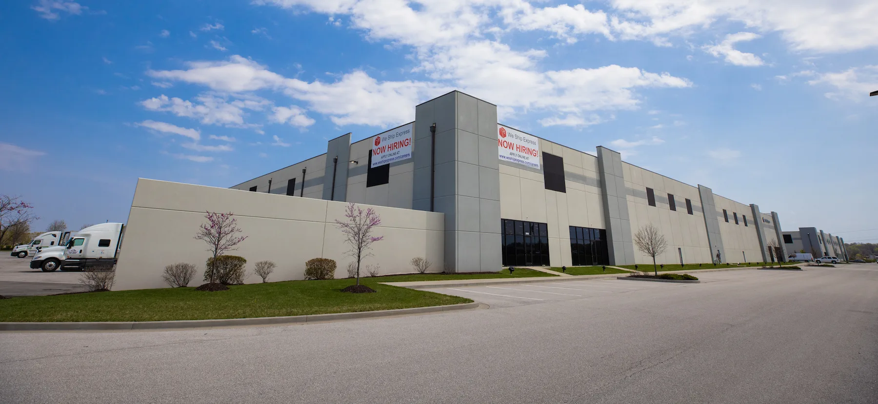 WeShip warehouse facility with Now Hiring banner hung on the building